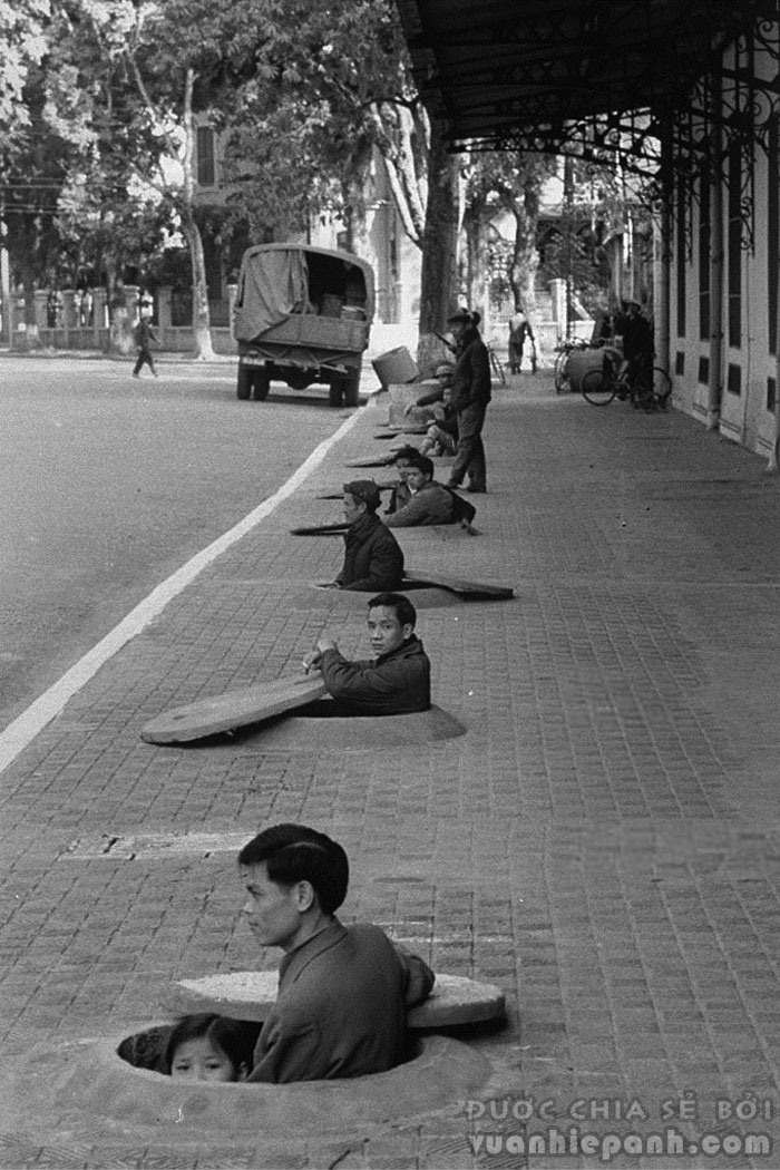 1967. Cư dân Hà Nội ngồi trong hố trú bom cá nhân đợi còi báo hiệu chấm dứt không kích.